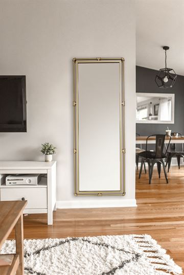 Spegel med ram av guldfärgade järnrör